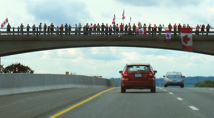 On August 24, 2007, the portion of the highway between Glen Miller Road in Trenton and the Don Valley Parkway/Highway 404 Junction in Toronto was designated the Highway of Heroes. This portion of road is travelled by funeral convoys for fallen Canadian Forces personnel from CFB Trenton to the coroner's office in Toronto. In this photo, people line the overpass in 2008 to pay respects to a fallen soldier.