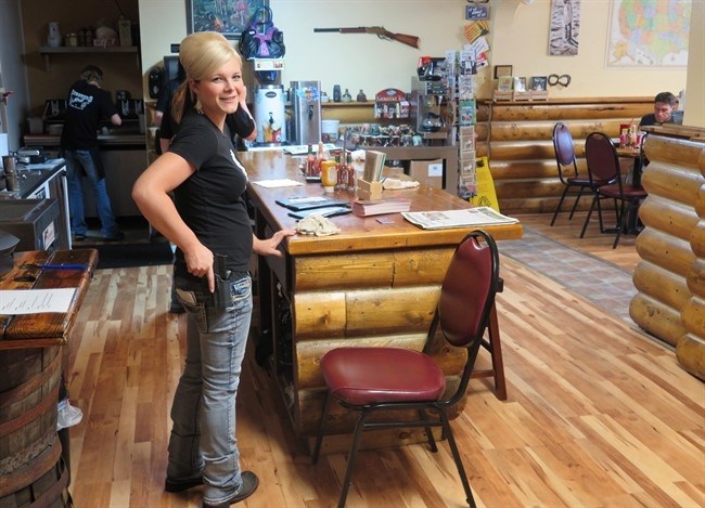 Waitress Dusty Sheets poses in Shooters Grill on Aug. 22, 2014, a restaurant in Rifle, Colo., where the staff are armed with handguns. So are many of the patrons.