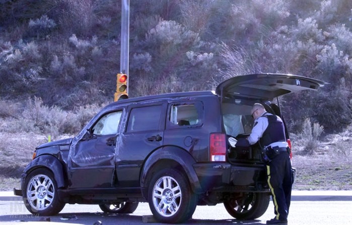 An officer searches the back of the vehicle after a driver allegedly fled