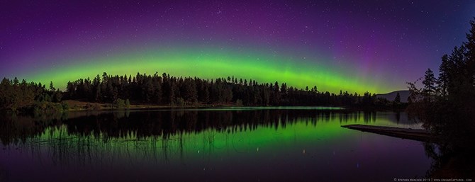 A six image stitch of the northern lights reflecting on Brunell Lake near Oliver BC. 
