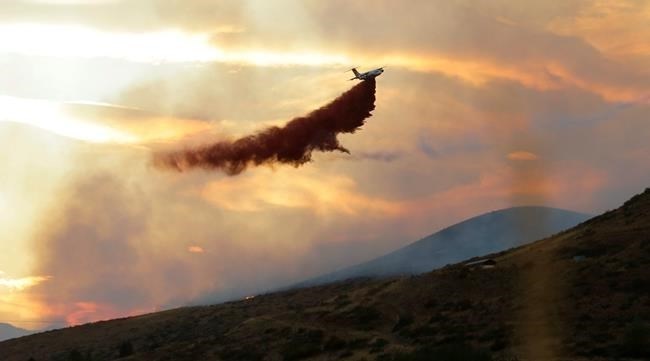 A plane drops fire retardant on a wildfire near Twisp, Wash. Wednesday, Aug. 19, 2015. Authorities on Wednesday afternoon urged people in the north-central Washington town to evacuate because of a fast-moving wildfire.