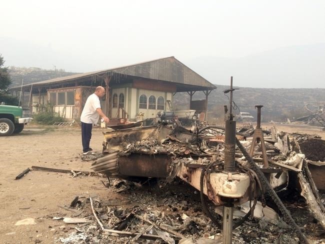 Steve Surgeon surveys the ruins after he lost everything he owned except his home in a wildfire on the outskirts of Okanogan, Wash., Sunday, Aug. 23, 2015.