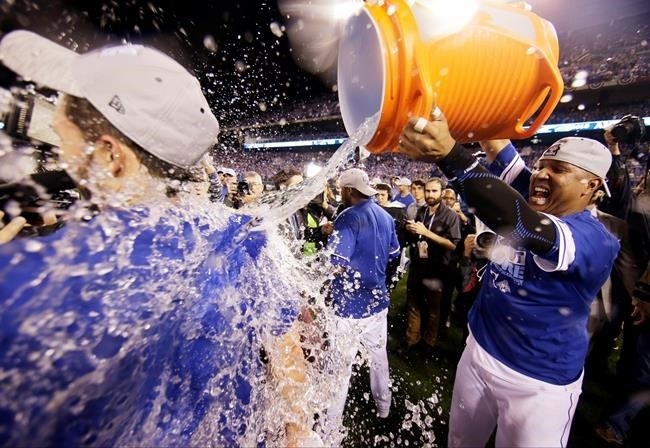 Kansas City Royals catcher Salvador Perez, right, soaks first baseman Eric Hosmer after their 4-3 win against the Toronto Blue Jays in Game 6 of baseball's American League Championship Series on Friday, Oct. 23, 2015, in Kansas City, Mo.