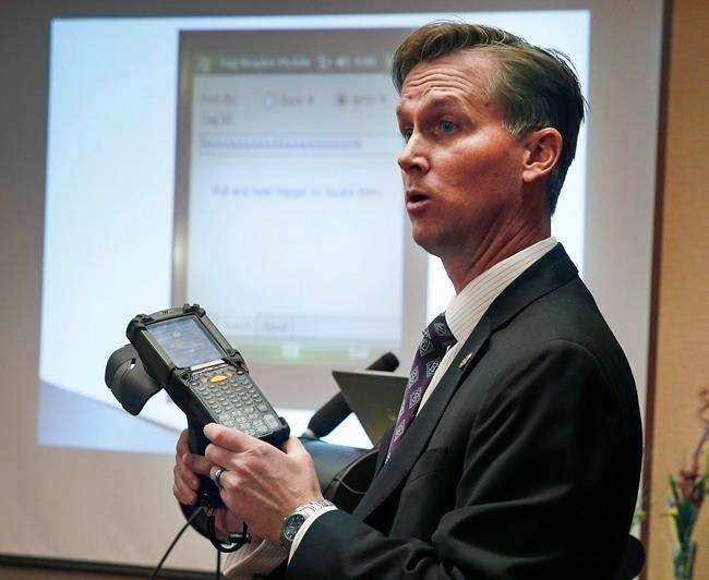 FILE - Lewis Koski, chief investigator of the Colorado Marijuana Enforcement Division, demonstrates a handheld radio-frequency reader, which is part of its new marijuana inventory tracking system, known as MITS, during a news conference, in Denver, Wednesday, Dec. 11, 2013.