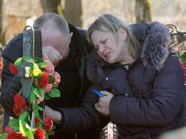 Nina Lushchenko's nephew Pavel and daughter Veronika react at her grave, after her funeral at a cemetery in the village of Sitnya, 80 km (about 50 miles) of Veliky Novgorod, Russia, Thursday, Nov. 5, 2015. The first victim of Saturday's plane crash in Egypt was laid to rest on Thursday following a funeral service in a medieval church in the north Russian city of Veliky Novgorod. Russia's Airbus 321-200 broke up over the Sinai Peninsula en route from the resort town of Sharm el-Sheikh to St. Petersburg, killing all 224 on board.
