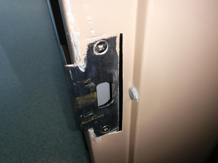 The damaged metal plate and door frame.