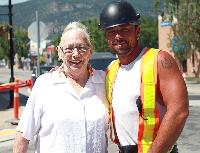 Penticton resident Lee Ballash gets a helping hand across the street while reconstruction efforts continue on Penticton's Main Street by Grizzly Excavating's Rob Kole.