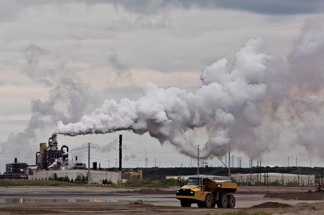 FILE PHOTO - A dump truck works near the Syncrude oil sands extraction facility near the city of Fort McMurray, Alta., on June 1, 2014. 