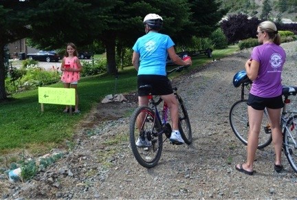 Taylor Denomme at Klub Kal offers lemonade to cyclists who are showing their support with rail trail t-shirts.