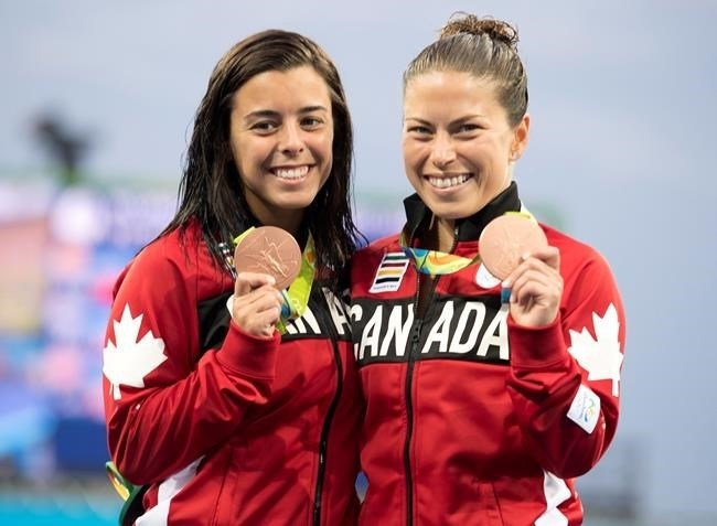Canada's Meaghan Benfeito (left) and Roseline Filion celebrate on the podium after their bronze medal win in women's synchronized 10-meter platform diving at the 2016 Summer Olympics in Rio de Janeiro, Brazil, Tuesday, Aug. 9, 2016.