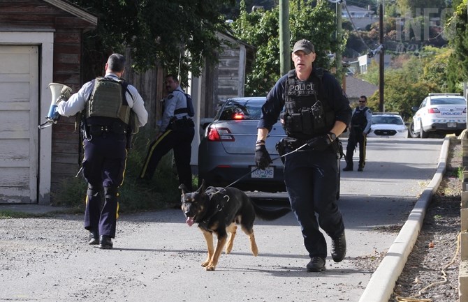 Kamloops RCMP officer and a police dog prepare to enter a house at 146 Columbia St., Monday, Sept. 26