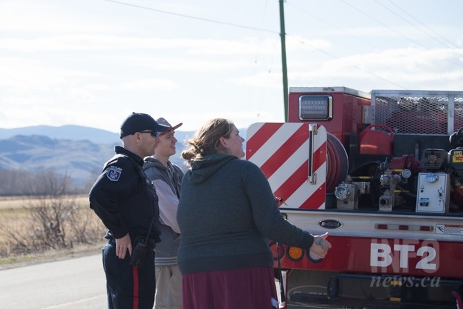 A bylaw officer, Bryan Johnson and his mother look on while rescue crews work to extract Steven Latchford.