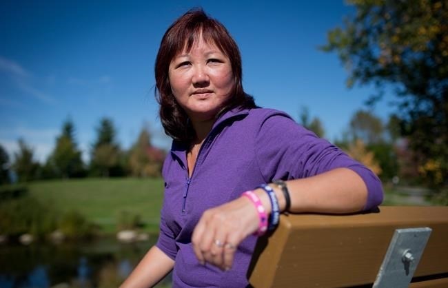 FILE PHOTO - Carol Todd sits on a bench dedicated to her late daughter Amanda Todd at Settlers Park in Port Coquitlam, B.C., on Sunday October 5, 2013. The mother of a British Columbia teenager who took her own life after enduring cyberbullying says it's 