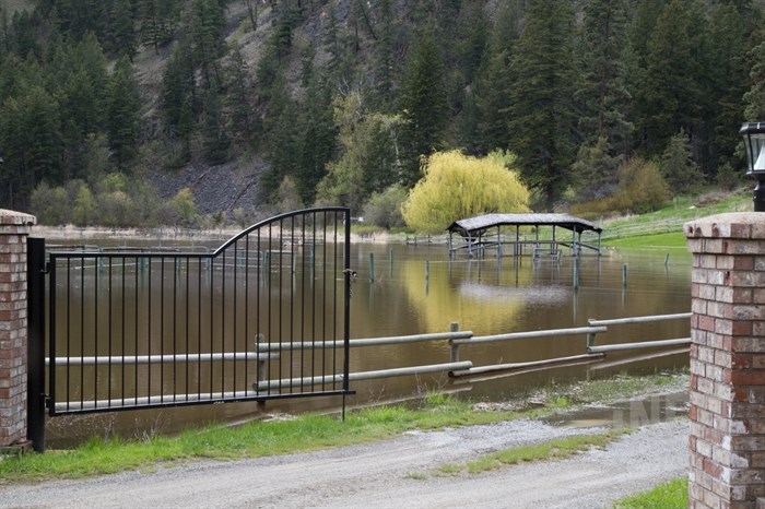 A Barnhartvale resident's front yard and driveway is covered in water. 
