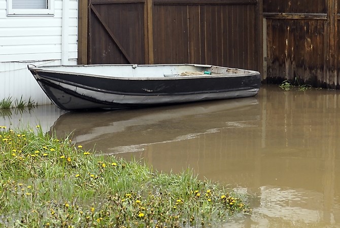 A boat floats in the front yard of a home under water on Commonwealth Road in Lake Country, Thursday, May 11, 2017.