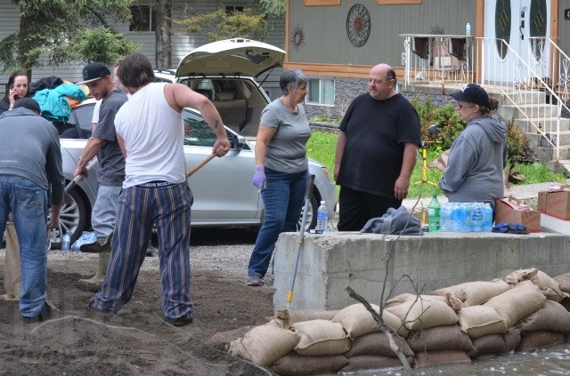 Members of the community chipped in to help Ted and Shannon Walker build sandbag dikes on their property along BX Creek in Vernon, Friday, May 12, 2017.