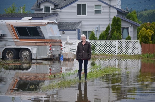 Solveig Anderson stands in water that has pooled around the Louis Estates neighbourhood on the Okanagan Indian Band reserve.