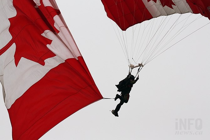 A Skyhawk parachutist trails a huge Canadian flag prior to landing in Okanagan Lake Park yesterday, Aug. 9, 2017.