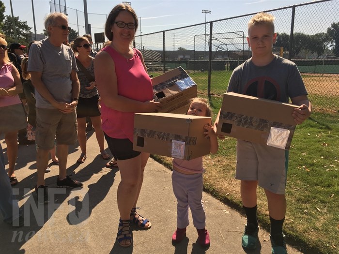 Christine Barnard and two of her three children, Gwyneth and Zachary, stand with their homemade viewing boxes at the Kelowna Curling Club to see the solar eclipse, Monday, Aug. 21, 2017.