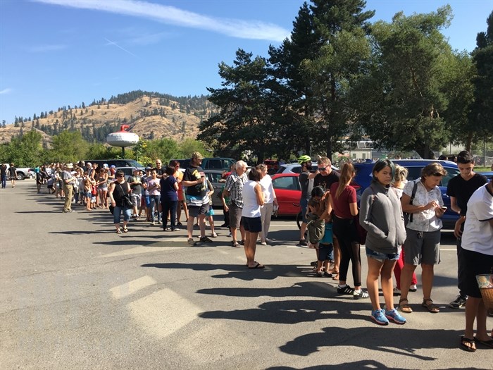 Hundreds of people line up at the Kelowna Curling Club to view the solar eclipse through a telescope provided by the Okanagan Centre of the Royal Astronomical Society of Canada, Monday, Aug. 21, 2017.
