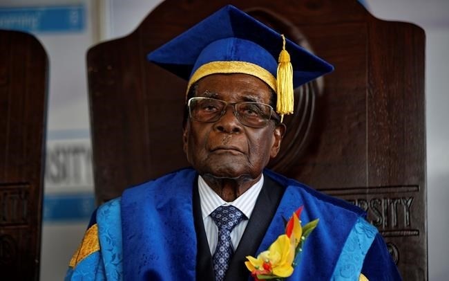 Zimbabwe's President Robert Mugabe sits for formal photographs with university officials, after presiding over a student graduation ceremony at Zimbabwe Open University on the outskirts of Harare, Zimbabwe Friday, Nov. 17, 2017.