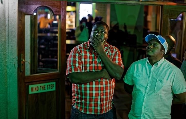 Disappointed Zimbabweans watch a televised address to the nation by President Robert Mugabe at a bar in downtown Harare, Zimbabwe Sunday, Nov. 19, 2017.