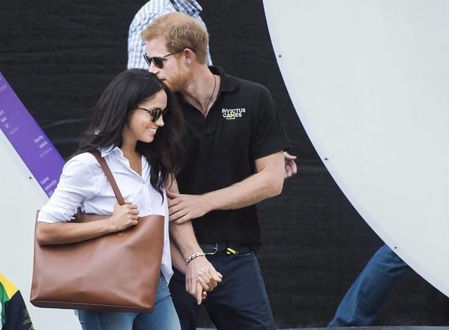 FILE - Prince Harry, right, arrives with his girlfriend Meghan Markle arrive to wheelchair tennis during the Invictus Games in Toronto on Monday, September 25, 2017. Her future home is on the grounds of Kensington Palace, but Meghan Markle's recent years have reportedly been spent living on a quiet, tree-lined street in Toronto with her two rescue dogs, Bogart and Guy. 