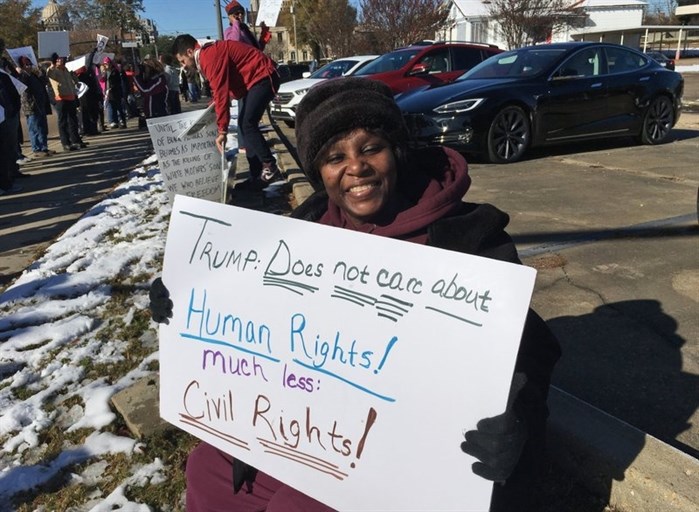 Gladys Bunzy of Jackson, Miss., protests Saturday, Dec. 9, 2017, against the visit of President Donald Trump in Jackson, Miss.