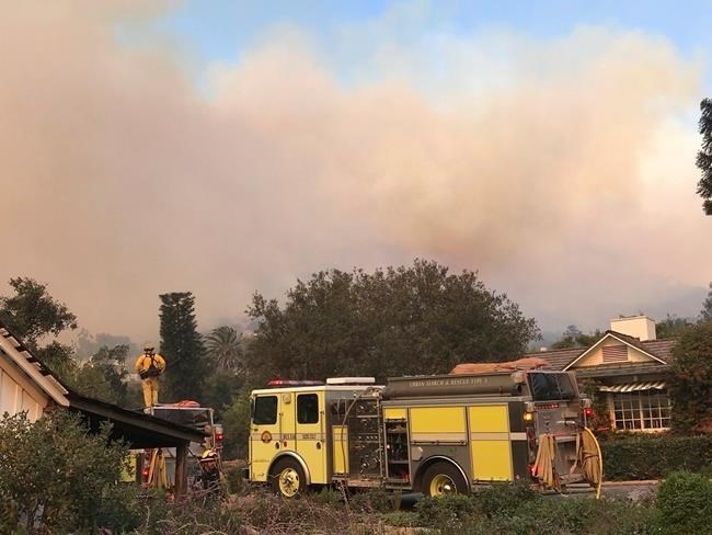 In this photo provided by the Santa Barbara County Fire Department, fire engines provide structure protection at the historic San Ysidro Ranch in Montecito, Calif., Saturday, Dec. 16, 2017. 