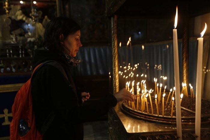 A Christian lights candles at the Church of the Nativity, built atop the site where Christians believe Jesus Christ was born, on Christmas Eve, in the West Bank City of Bethlehem, Sunday, Dec. 24, 2017.