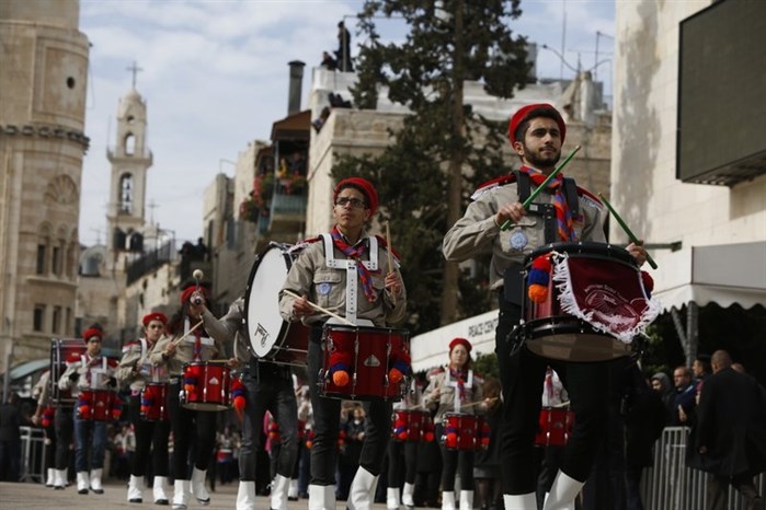 Members of a Palestinian marching band parade during Christmas celebrations outside the Church of the Nativity, built atop the site where Christians believe Jesus Christ was born, on Christmas Eve, in the West Bank City of Bethlehem, Sunday, Dec. 24, 2017.