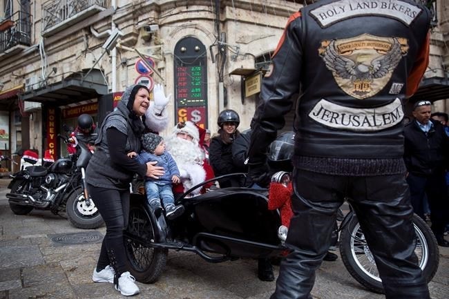 A man dressed as Santa Claus sits in a sidecar of a motorbike on Christmas Eve in Jerusalem Old City Sunday, Dec. 24, 2017.