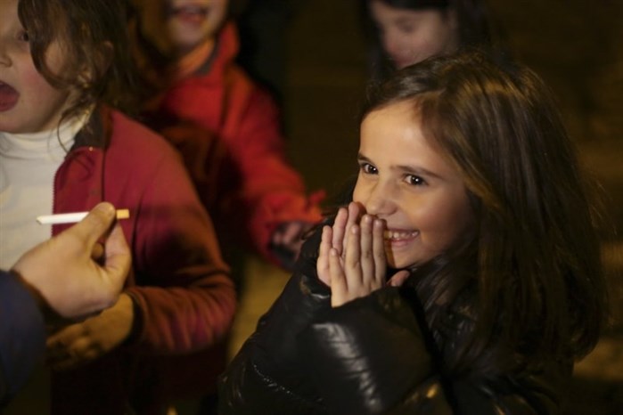 Ines, 8, reacts as her father Frederico hands her her first cigarette, in the village of Vale de Salgueiro, northern Portugal, during the local Kings’ Feast Friday, Jan. 5, 2018.