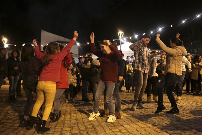 Children and adults dance the Murinheira, a traditional dance of Celtic origin, in the village of Vale de Salgueiro, northern Portugal, during the local Kings’ Feast Friday, Jan. 5, 2018.
