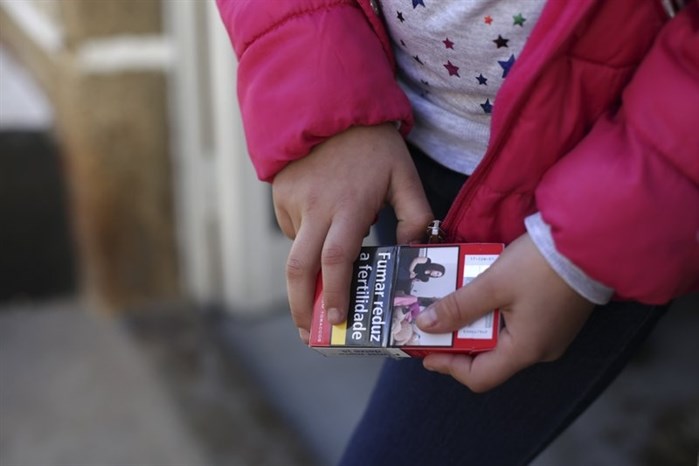Natasha, 8, holds a packet of cigarettes in the village of Vale de Salgueiro, northern Portugal, during the local Kings’ Feast Saturday, Jan. 6, 2018.