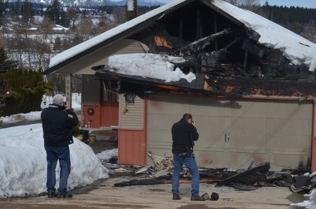 Fire investigators photograph evidence at one of the houses targeted in the early morning hours of March 9, 2018. 