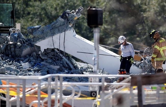 Rescue workers walk on the rubble after a brand-new pedestrian bridge collapsed at Florida International University in Miami on Thursday, March 15, 2018.