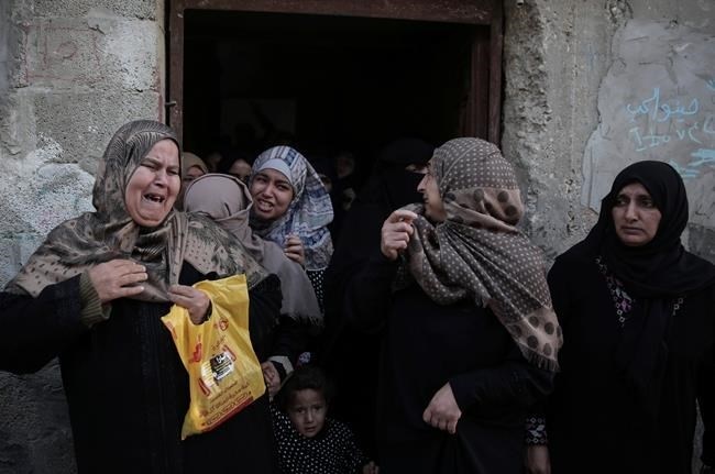 Palestinian relatives of 29-year-old Fares al-Reqeb, who died Monday of his injuries, react while mourners carry his body out of the family house during his funeral in the town of Khan Younis, Monday, April 2, 2018.