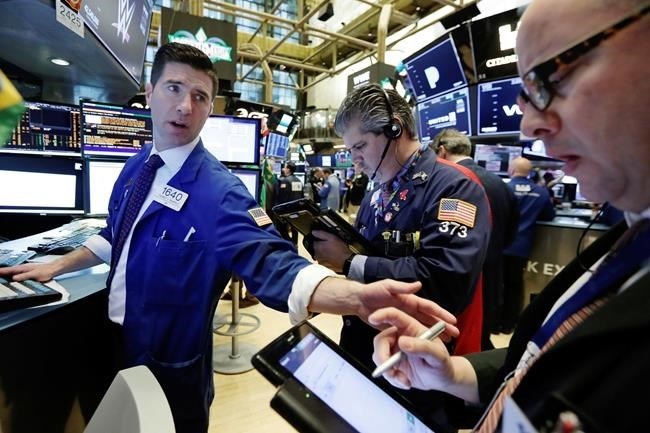 Specialist Thomas McArdle, left, works with traders John Panin, center, and Jeffrey Vazquez on the floor of the New York Stock Exchange, Monday, April 2, 2018. U.S. stocks are skidding Monday morning after China raised import duties on U.S. pork, apples and other products.