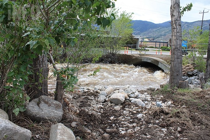 Water rushes under the bridge connecting the Wholesale Club parking lot with Industrial Avenue in Penticton this morning. The bridge has been closed following efforts to open up the creek in front of the bridge Wednesday, May 9, 2018.