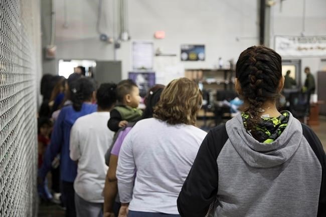 In this photo provided by U.S. Customs and Border Protection, people who've been taken into custody related to cases of illegal entry into the United States, stand in line at a facility in McAllen, Texas, Sunday, June 17, 2018.