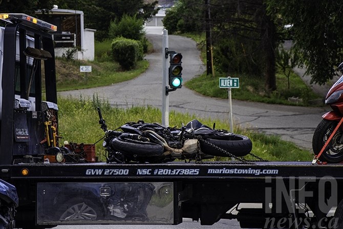 A motorcycle is seen on a flatbed trailer near the scene of the accident. 