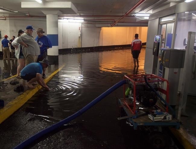 Toronto Blue Jays fans get stuck in the Rogers Centre as the entrance to the parking garage floods with torrential rain, in Toronto on Tuesday, August 7, 2018. 