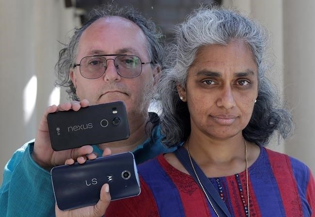 In this July 25, 2018 photo, Kalyanaraman Shankari, right, and her husband Thomas Raffill hold their phones while posing for photos in Mountain View, Calif. An Associated Press investigation shows that using Google services on Android devices and iPhones allows the search giant to record your whereabouts as you go about your day.