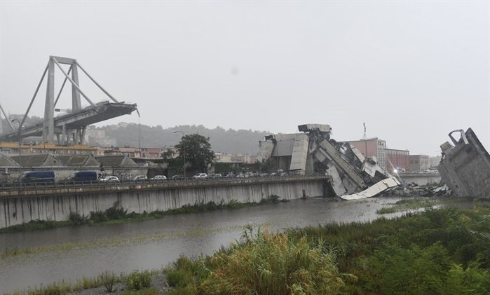 A view of the collapsed Morandi highway bridge in Genoa, northern Italy, Tuesday, Aug. 14, 2018. A large section of the bridge collapsed over an industrial area in the Italian city of Genova during a sudden and violent storm, leaving vehicles crushed in rubble below.