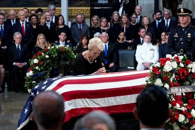 Cindy McCain, wife of, Sen. John McCain, R-Ariz., pauses at her husband's casket as he lies in state in the Rotunda of the U.S. Capitol, Friday, Aug. 31, 2018, in Washington.