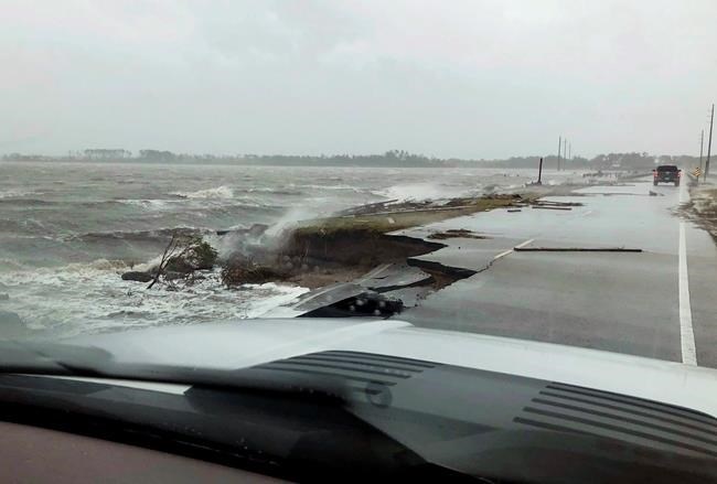 In this photo provided by Jordan Guthrie, wind and water from Hurricane Florence damages the highway leading off Harkers Island, N.C. on Friday, Sept. 14, 2018.