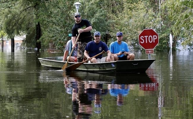 Residents paddle a boat through a flooded neighborhood in Lumberton, N.C., Monday, Sept. 17, 2018, in the aftermath of Hurricane Florence.