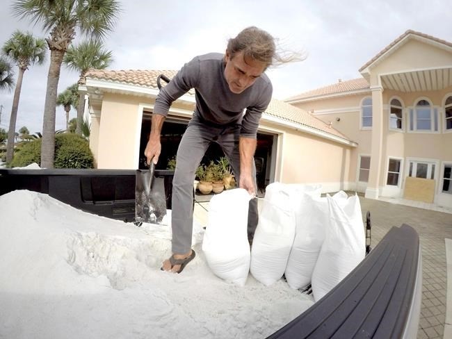 Rick Johnson fills sand bags on Tuesday, Oct. 9, 2018 at his Okaloosa Island home in Fort Walton Beach, Fla., in preparation for Hurricane Michael.