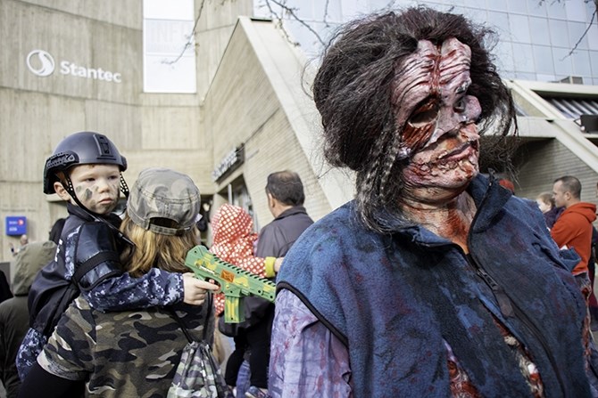 Chevonne Oginski and her son Owen, 3, crashed the march dressed as zombie hunters. Chevonne holds Owen as he watches Una Connor walk by in costume.